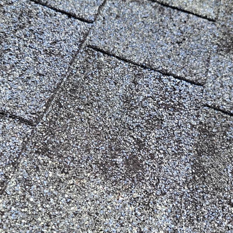 Roofing shingles close-up showing granular texture and wear Roofing shingles close-up showing granular texture and wear