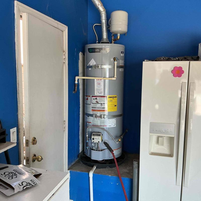 Water heater with sediment drainage setup in utility room