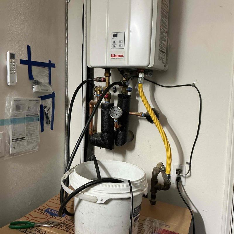 Tankless water heater flush with hoses and bucket