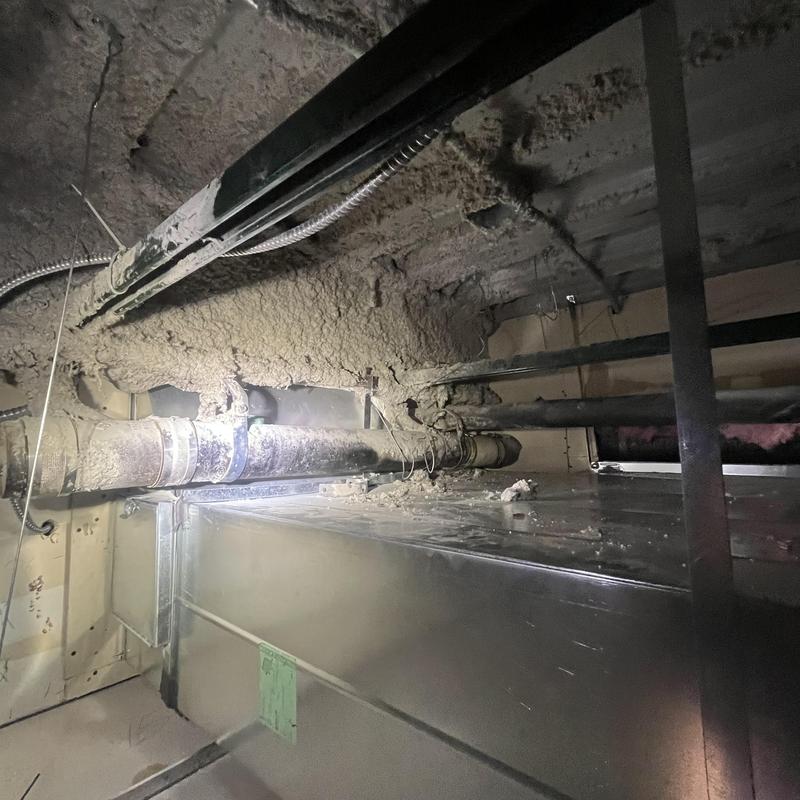 HVAC metal duct with insulation and piping in crawlspace