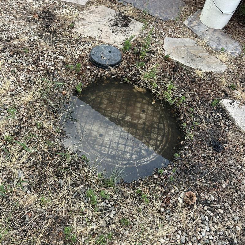 Sewer lift station manhole with standing water outdoors