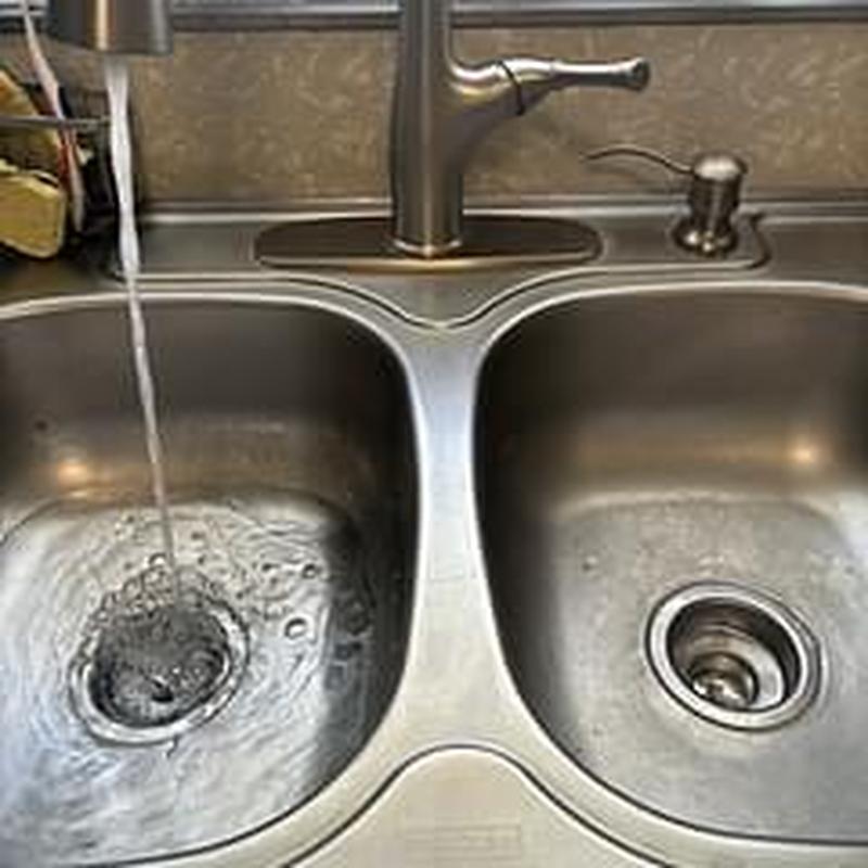 Basket strainers in double kitchen sink with running water Basket strainers in double kitchen sink with running water