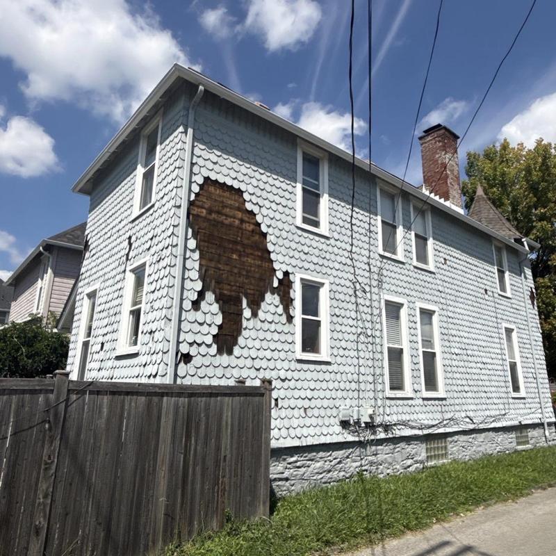 Wood scallop siding with damaged section on house exterior
