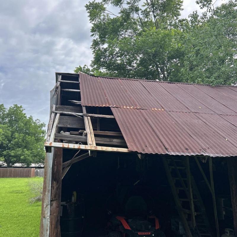 Corrugated metal barn roof with rust and damage