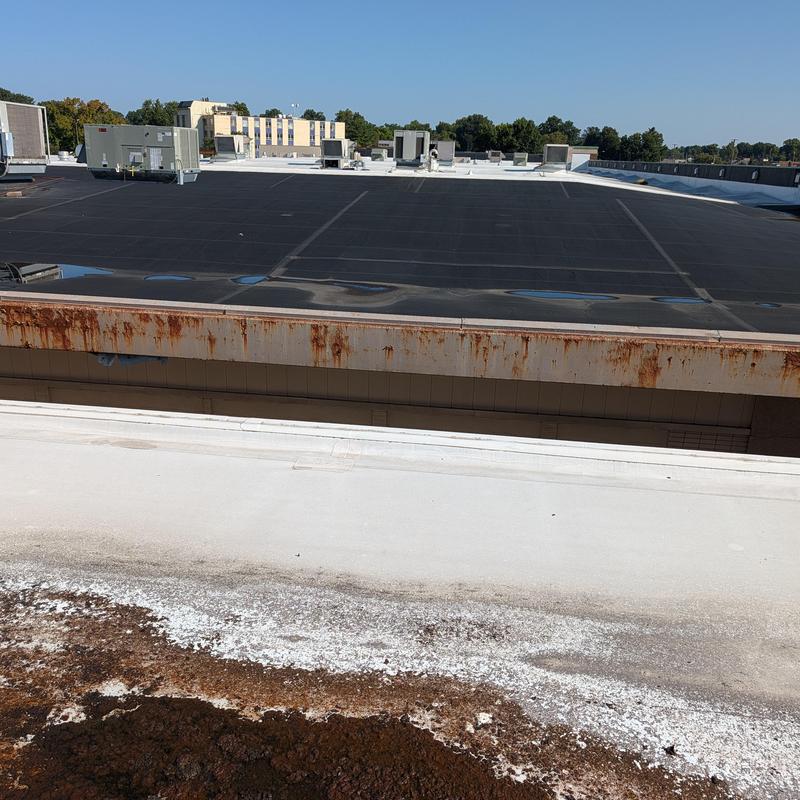 EPDM flat roof with rusted metal edge prep for TPO restoration