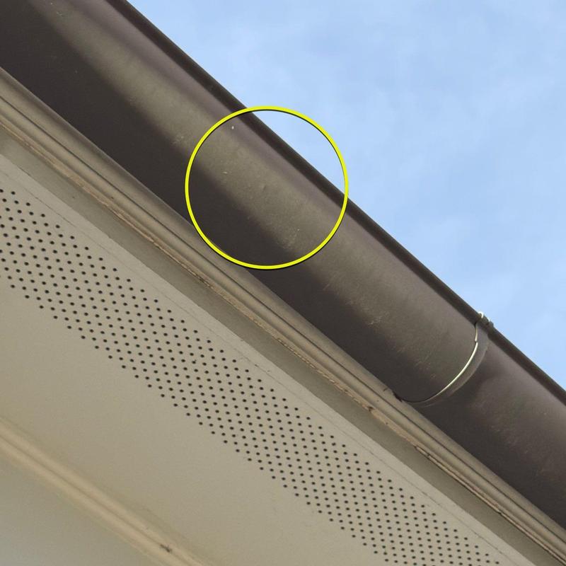 Gutter with hail damage dents highlighted in yellow