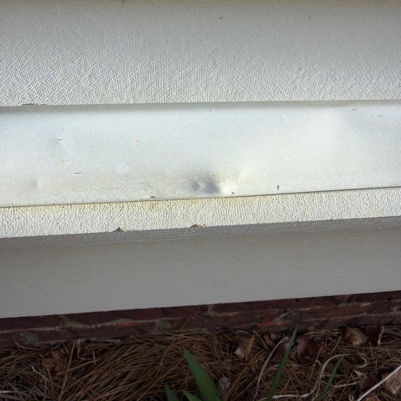 Metal drip edge with hail impact dents and surface damage