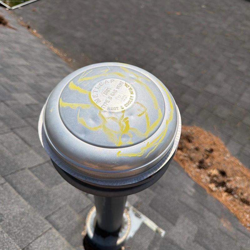Roof gas vent with hail damage and markings