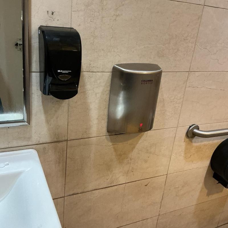 Soap dispenser and hand dryer in men's handicap stall Soap dispenser and hand dryer in men's handicap stall