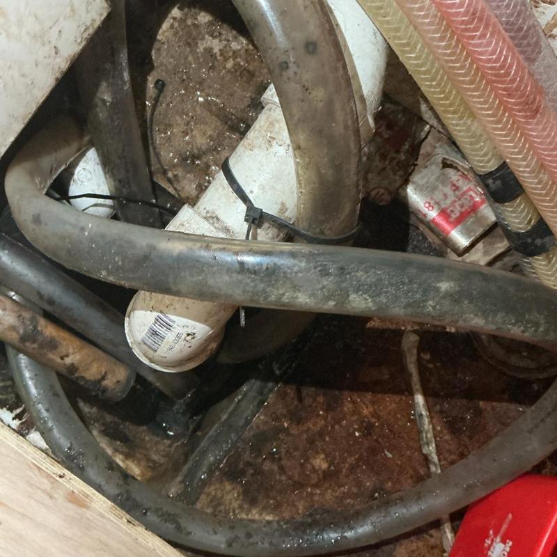 Drain hose and PVC pipe connection with water puddle Drain hose and PVC pipe connection with water puddle