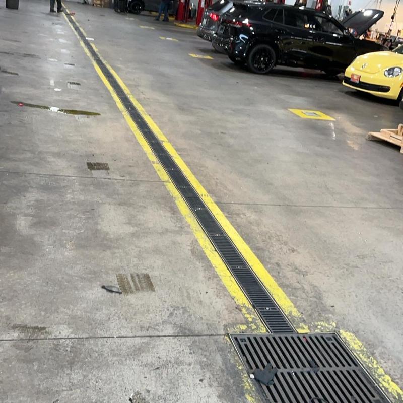 Trench drain grates with yellow safety lines in garage Trench drain grates with yellow safety lines in garage