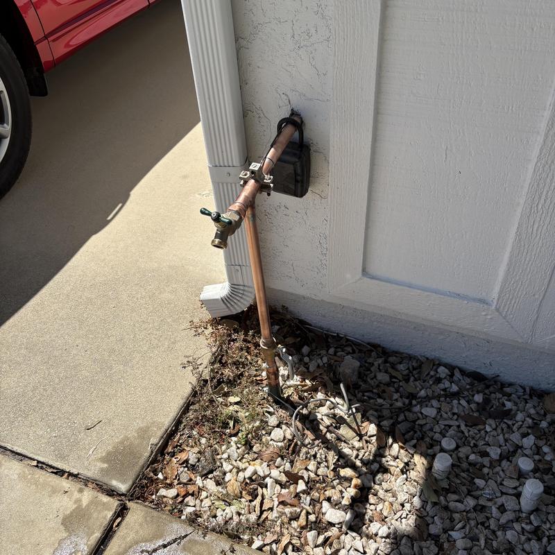 Copper water main riser with outdoor faucet in gravel bed