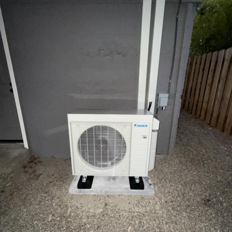 Residential Daikin heat pump unit on concrete pad Residential Daikin heat pump unit on concrete pad