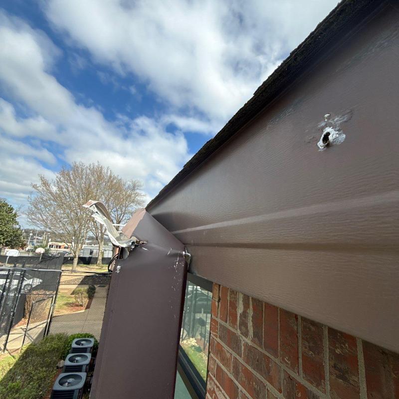 Metal gutter with hail damage on commercial building roof