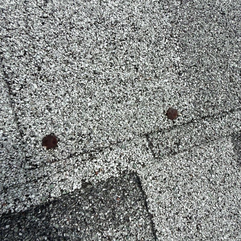 Asphalt shingle roof with rusted nails and granule wear