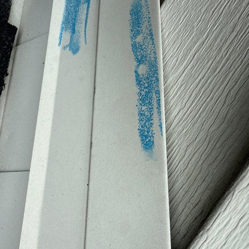 Roof shingles with blue hail damage markings