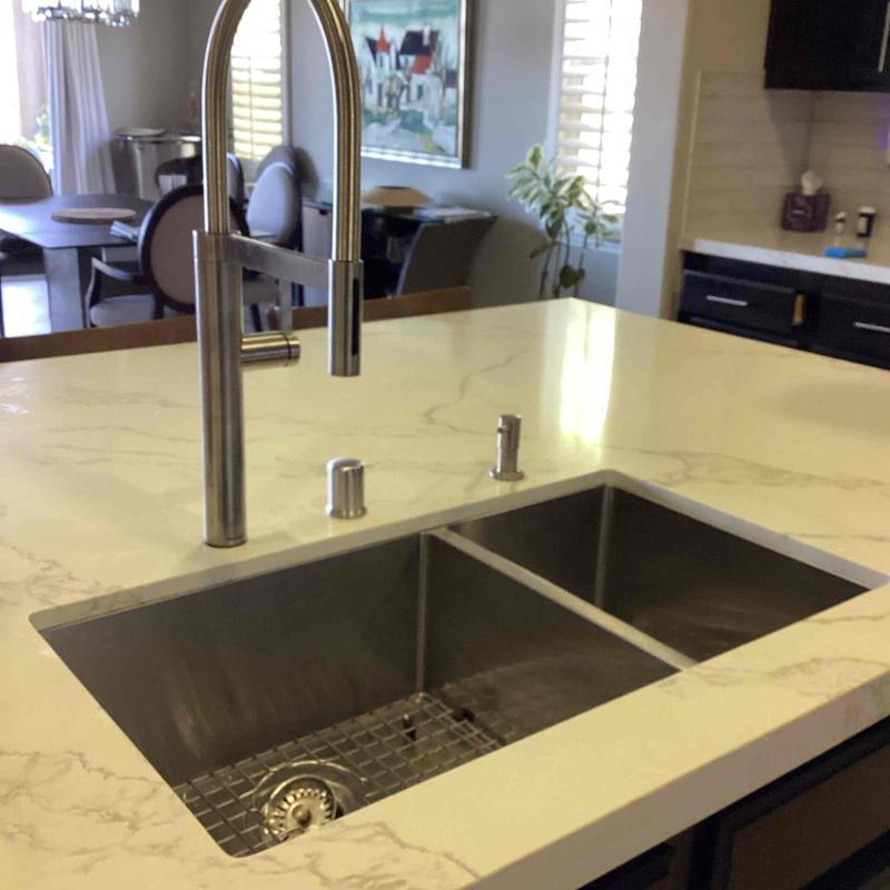 Kitchen sink with stainless steel faucet and soap dispenser