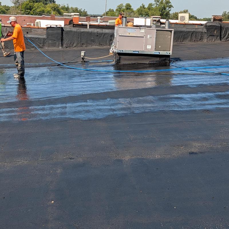 Commercial flat built-up roof cleaning with water hoses