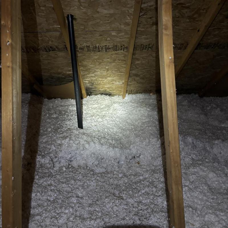 Roof insulation and attic vent pipe in Hayden ID attic