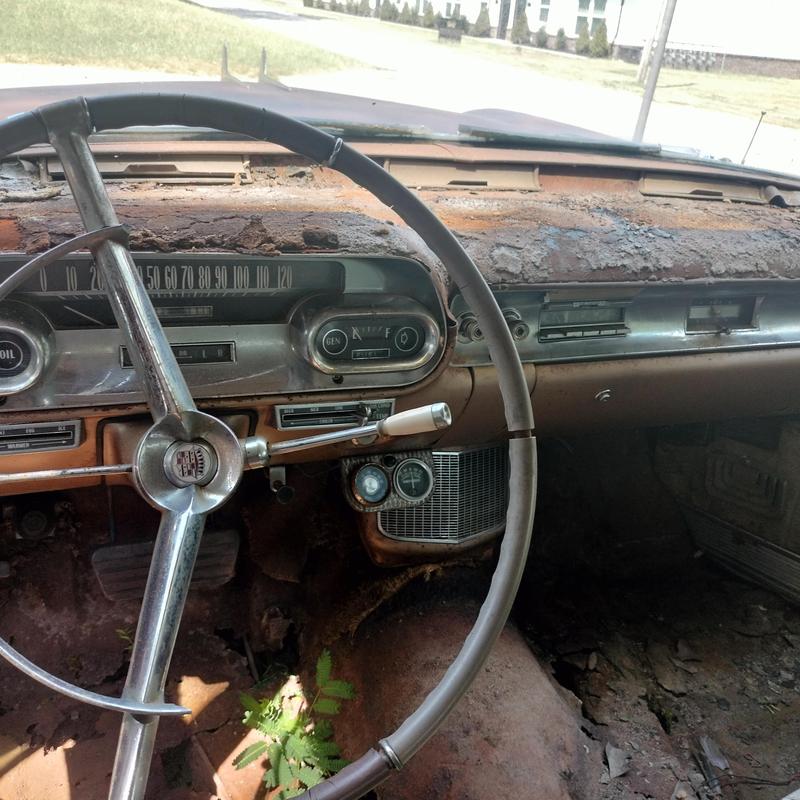Classic car dashboard and steering wheel with rust damage