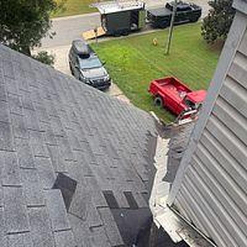 Asphalt shingle roof with missing shingles near gutter Asphalt shingle roof with missing shingles near gutter