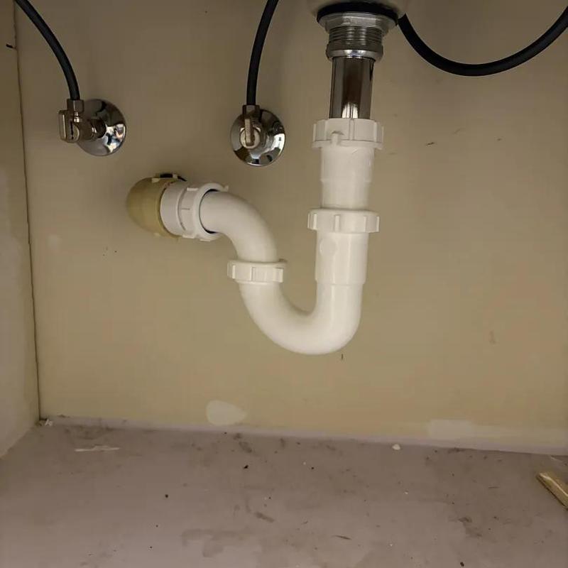 Sink drain trap and water shutoff valves under cabinet