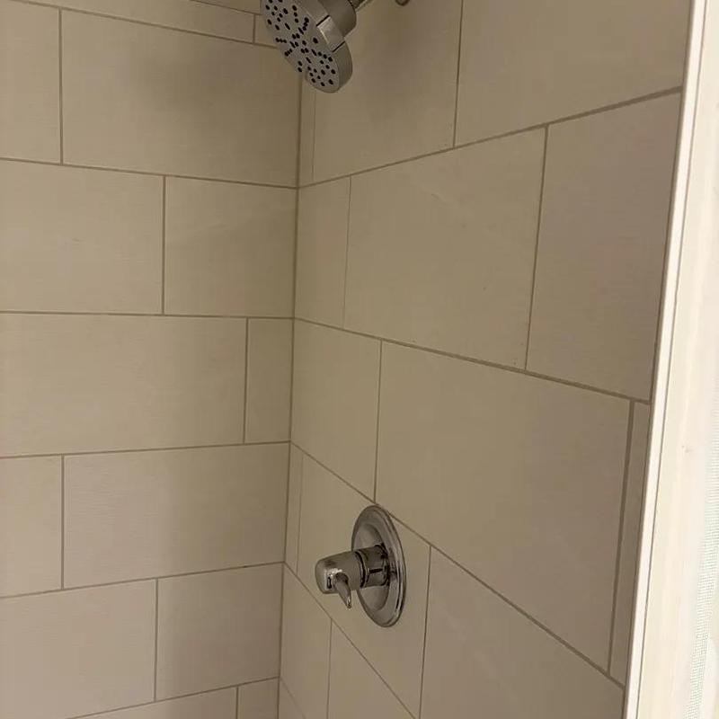 Shower fixture and valve installation in tiled bathroom