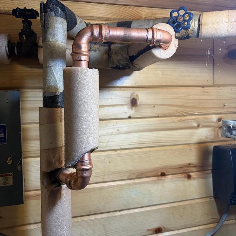 Copper water pipes with foam insulation in wooden wall