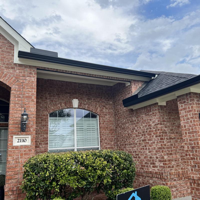 Seamless aluminum gutter system on brick home exterior