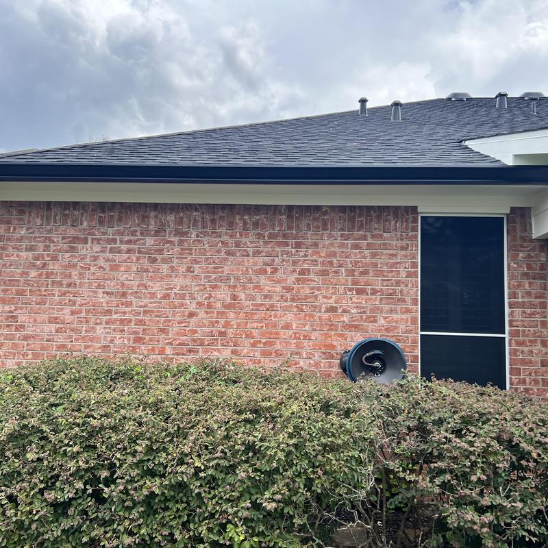 Seamless aluminum gutters installed on brick home exterior