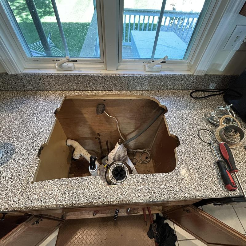 Kitchen sink cutout with removed sink and faucet parts Kitchen sink cutout with removed sink and faucet parts