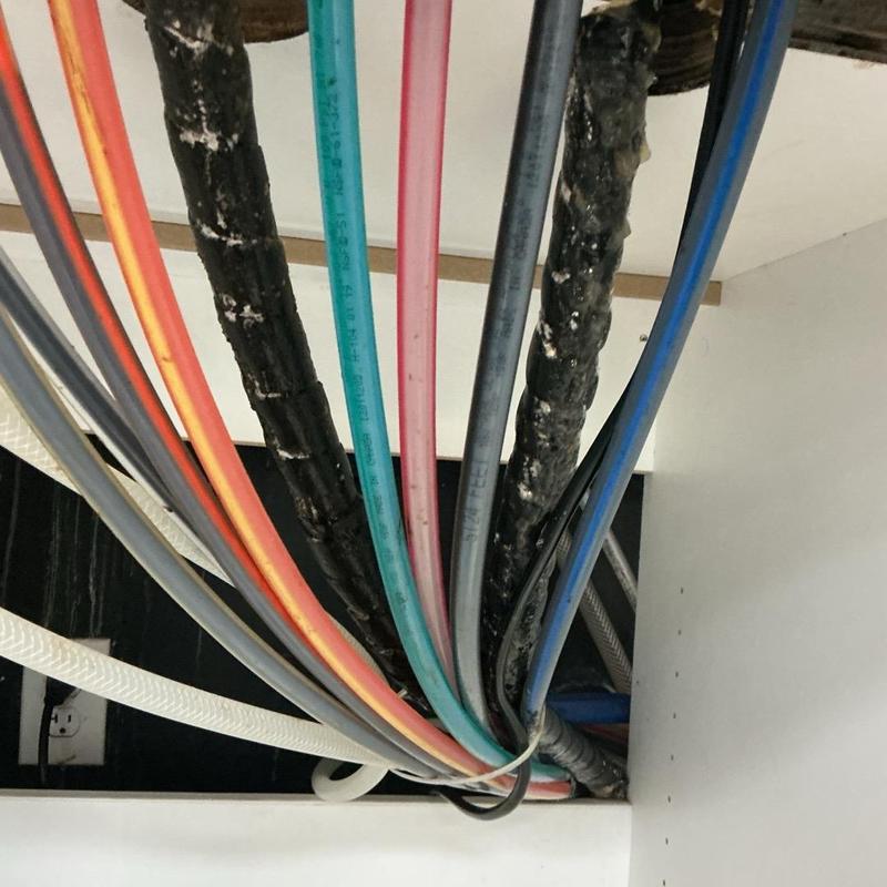 Soda machine drain hose and surrounding pipes under counter