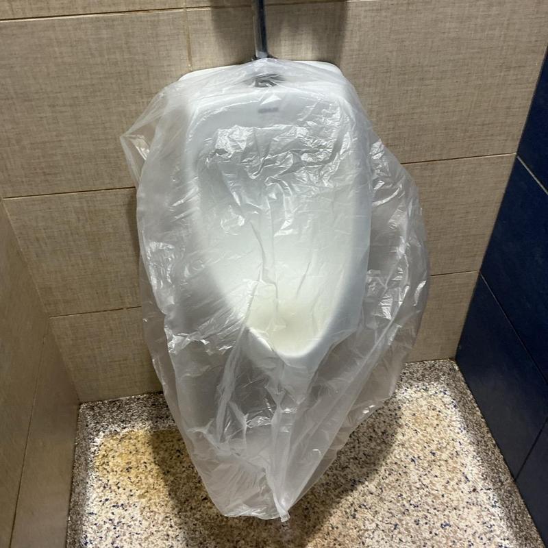 Urinal covered with plastic protective sheet indoors