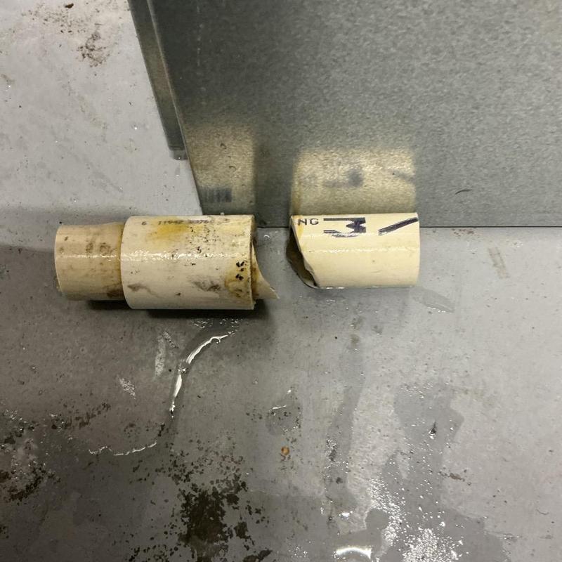 AC handler drain pipe with leak and water on floor