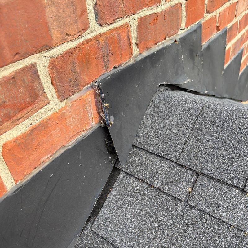 Roof flashing with damaged sealant on brick wall