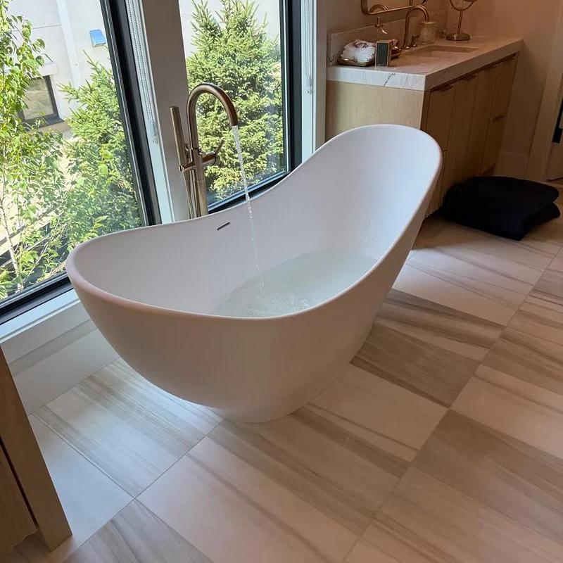 Freestanding bathtub with floor-mounted faucet filling