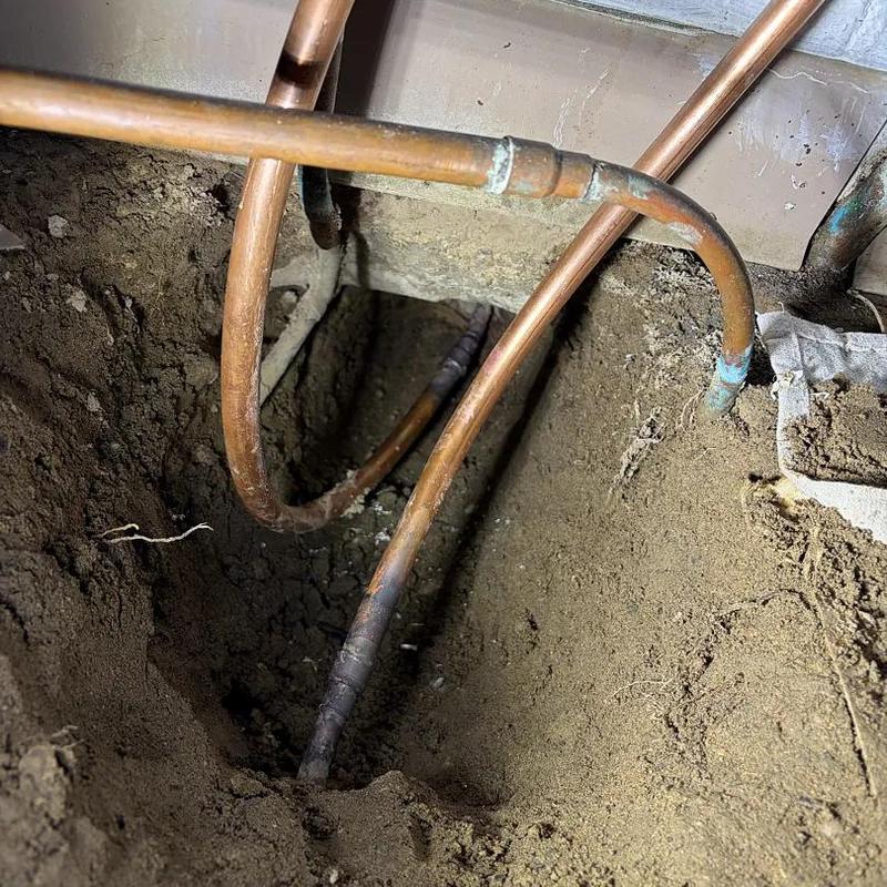 Copper water pipes exposed under concrete slab repair