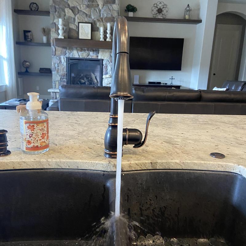 Kitchen sink faucet with running water on granite counter Kitchen sink faucet with running water on granite counter