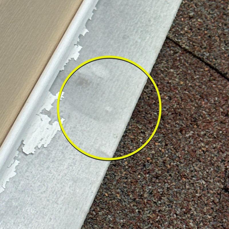 Metal drip edge with paint peeling near asphalt shingles
