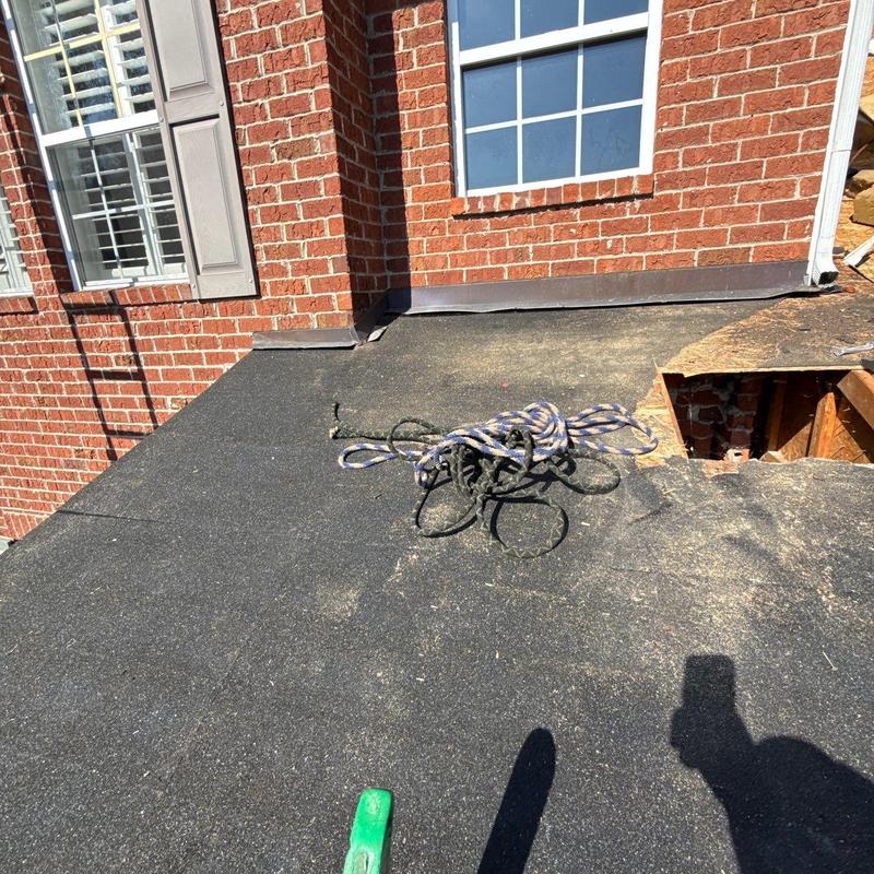 Flat roof edge with damaged roofing felt near window