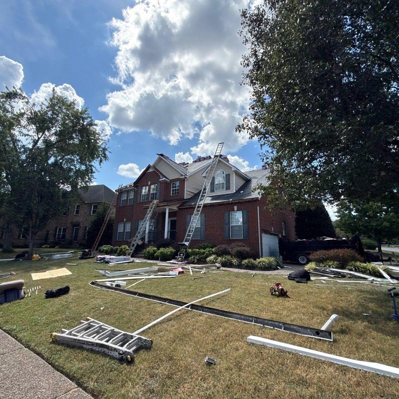 Roof shingles with hail damage and ladders set up