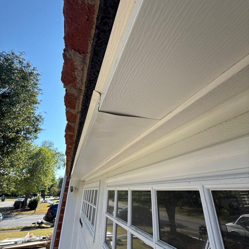 Soffit panel with visible corner gap near brick wall