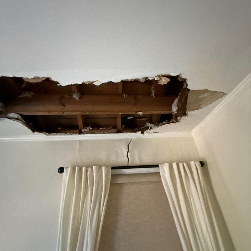 Ceiling drywall with large hole and water damage