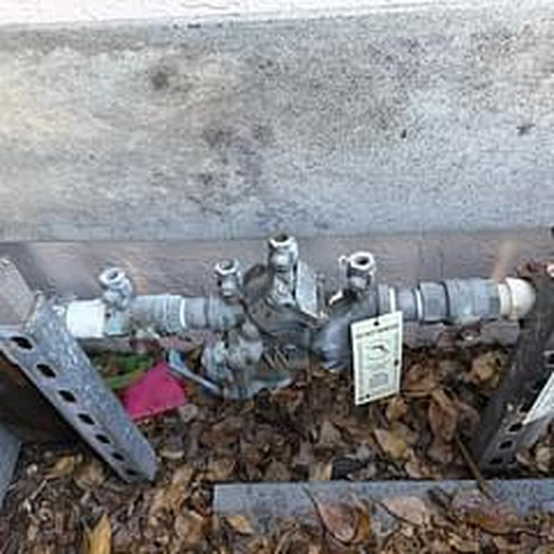 Backflow prevention device with inspection tag outdoors