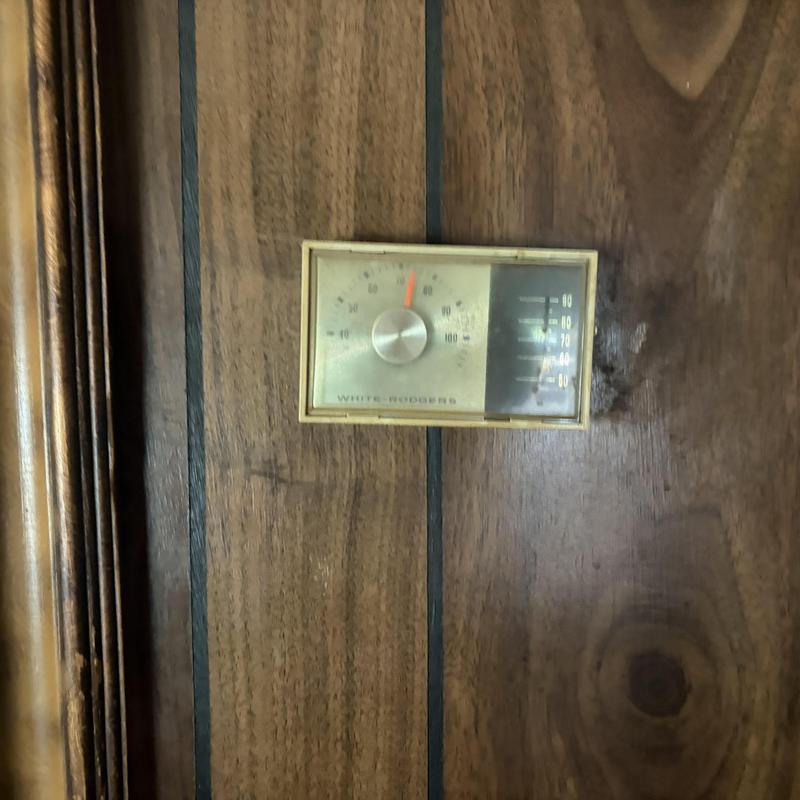 Wall furnace thermostat on wood panel wall Wall furnace thermostat on wood panel wall
