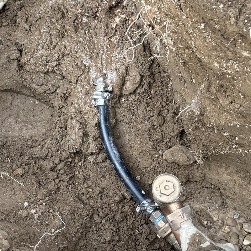 Water meter hose connection with hose clamps in soil Water meter hose connection with hose clamps in soil