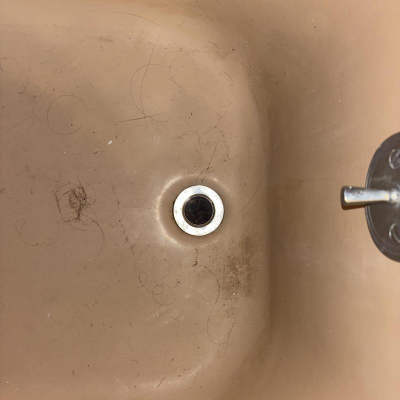 Bathtub drain clogged with hair and debris