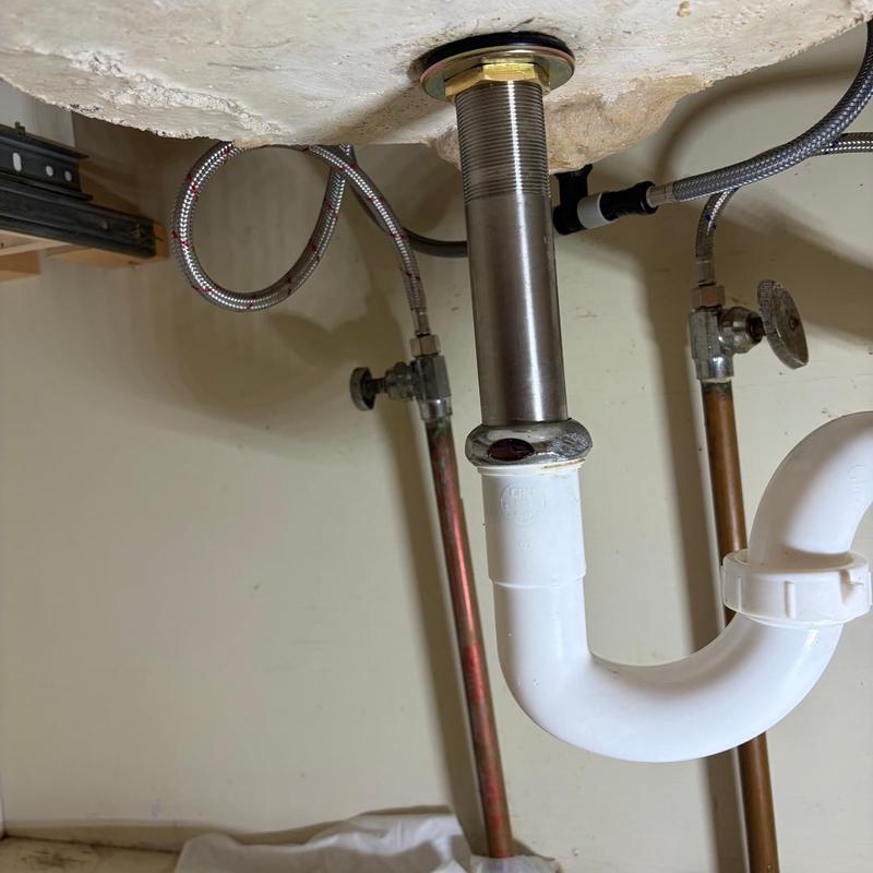 Vanity sink drain pipe and water supply lines under sink