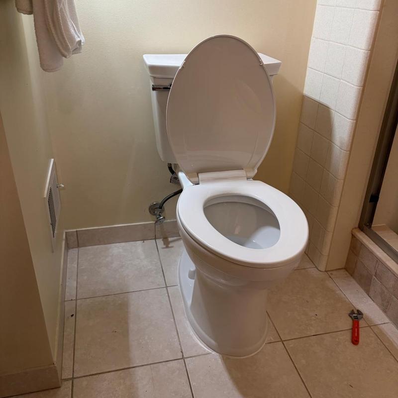 Toilet installation with open lid in bathroom corner