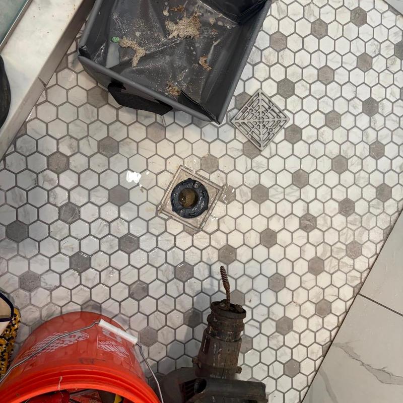 Shower drain cleaning with plumber’s snake and debris removal